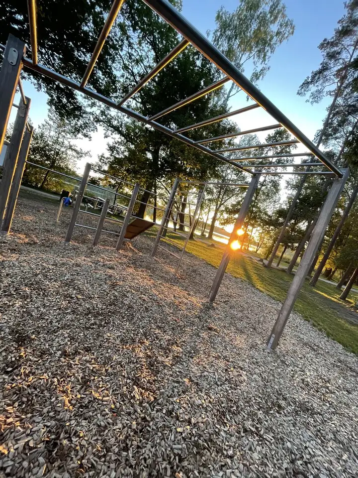 Golden Hour: Sonne scheint durch die Stangen eines Calisthenics-Parks