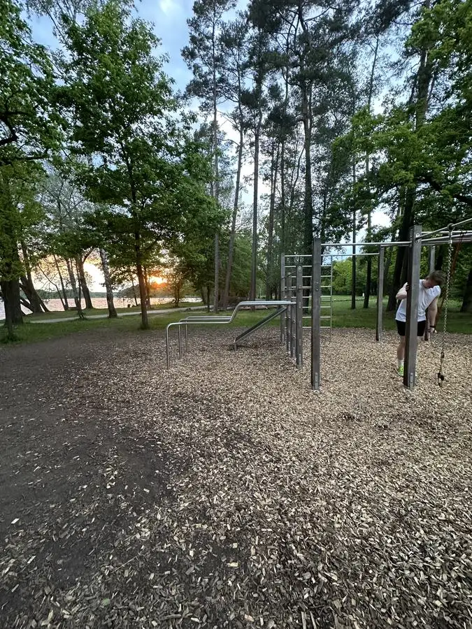 Front Lever am Calisthenics-Park im Wald bei Sonnenuntergang